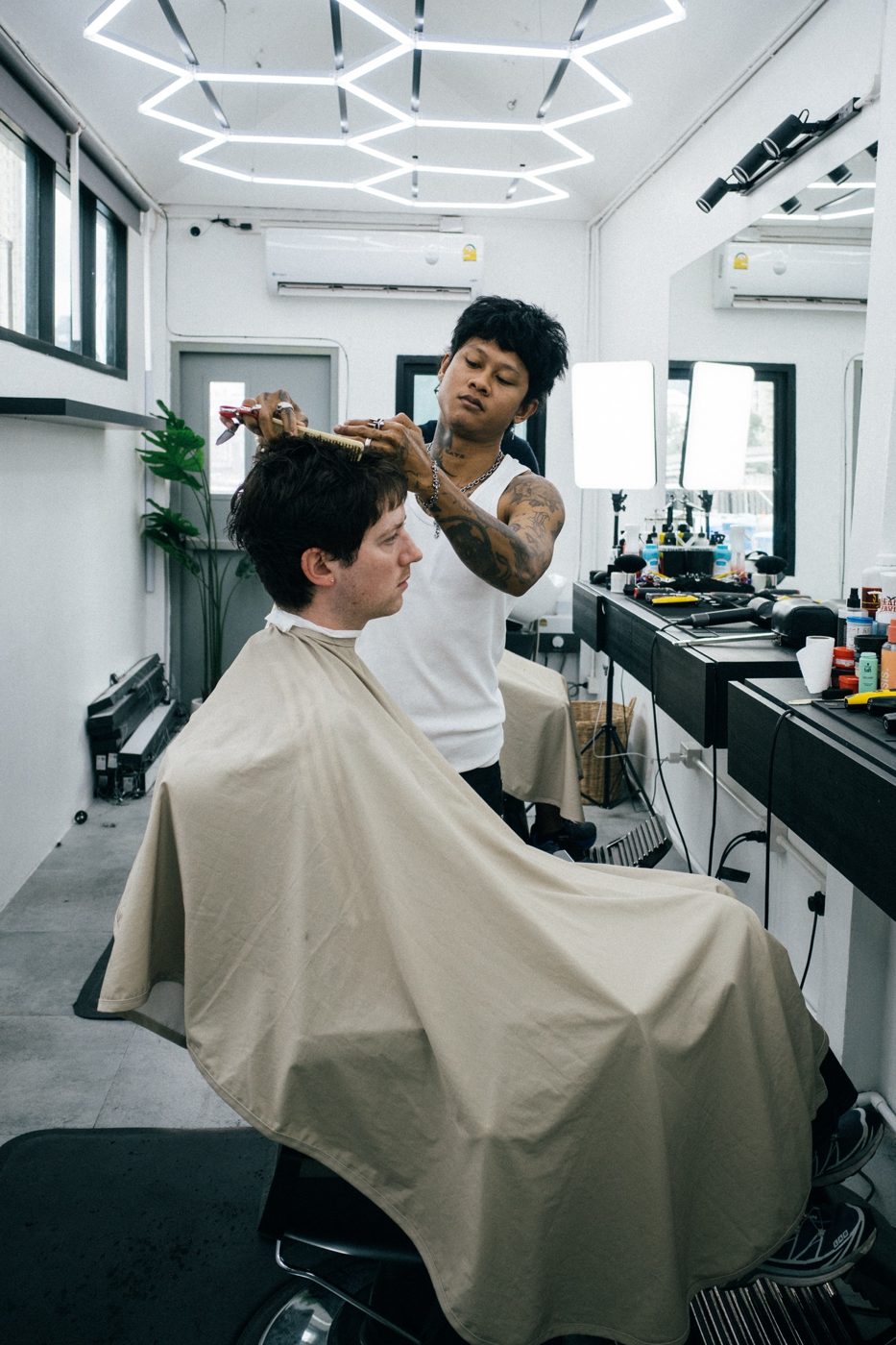 Guide — barber at Fijii Cuts Bangkok giving a haircut